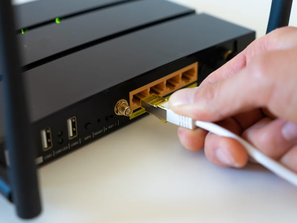 Ein Router von TP-Link an soeben ein Netzwerkkabel angeschlossen wird.